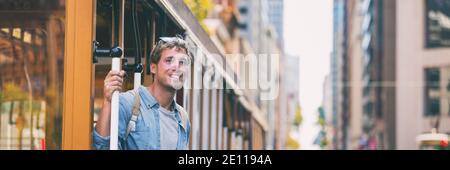 San Francisco man riding cable car tramway. Young casual guy in his 20s using public transport system in the city to travel to work or university Stock Photo