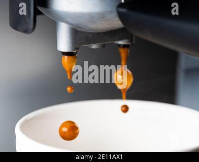 A espresso machine fills a cup of coffee. Close-up shot. Stock Photo