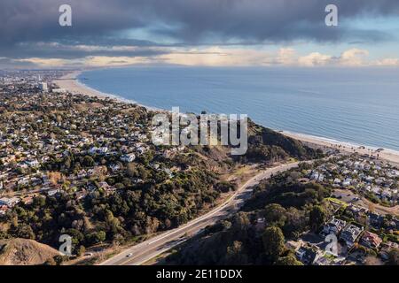 Aerial of Temescal Canyon Road and Pacific Palisades neighborhoods with stormy sky near Santa Monica Bay in Southern California. Stock Photo