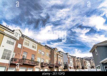 Dramatic skyscape of cloudy blue sky over townhouses with Wasatch mountain view Stock Photo