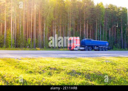 blue barrel truck with dangerous cargo is parked on the side of a forest road, transportation and safety Stock Photo