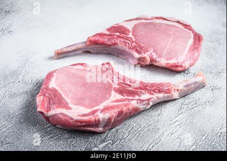 Raw dry aged tomahawk pork chop steak. White background. Top view Stock Photo