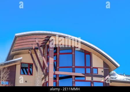 Home exterior with modern design featuring curved roof and large glass windows Stock Photo