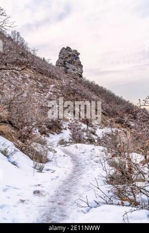 Snowy hiking trail in the rocky slope of mountain in Provo Canyon Utah in winter Stock Photo