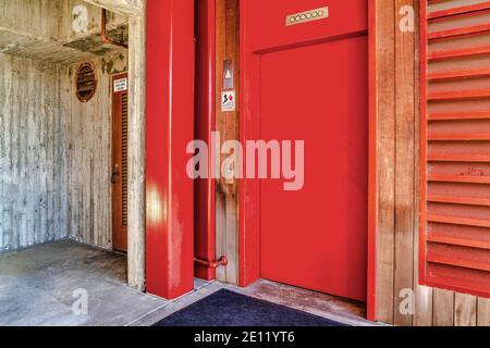 Vibrant red elevator door with buttons in San Diego California building exterior Stock Photo