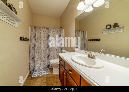 Residential bathroom design ideas with tile floor and printed shower curtain Stock Photo