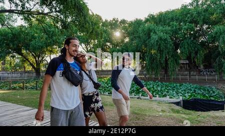 three friends laughing while walking along a path Stock Photo