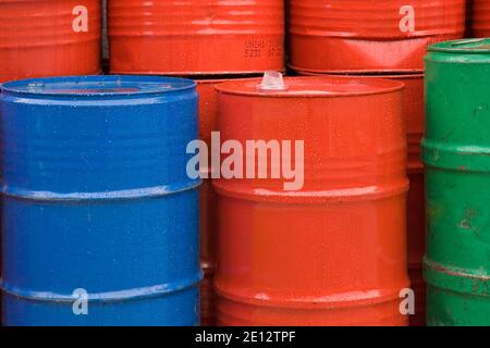 Many Colorful Metal Bins Filled With Various Machine Oils Are Piled Up In The Yard Of The Industrial Site Stock Photo