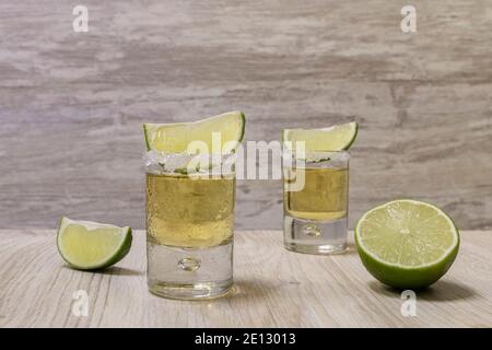 Tequila shots with salt and lime slices an a lime half Stock Photo