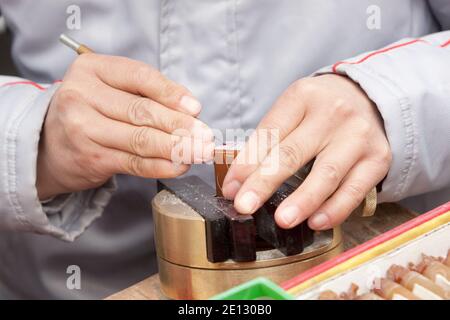 Beijing, China : Hands carving traditional stone name chops (name seals or name stamps) at Panjiayuan antique market. Stock Photo