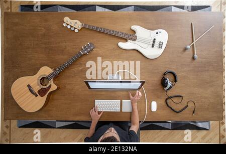 Top view of a composition of musical instruments on a wooden table in a recording studio. Musician's workplace for creativity. Stock Photo