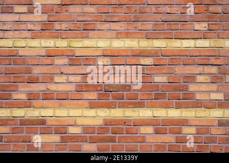 Background from a red brick wall with yellow stripes Stock Photo