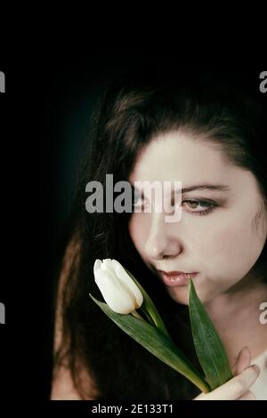 teenager with tulip in hand and romantic look Stock Photo