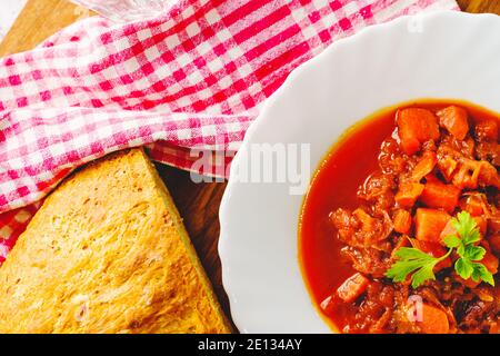 Top view on Borscht soup in plate - Fresh homemade Borsch traditional meal on table with copy space close up with slice of bread Stock Photo