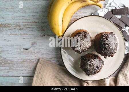 Top view flat lay on chocolate muffin cakes with banana on the table Stock Photo