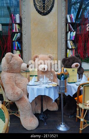 PARIS, FRANCE -24 DEC 2020- View of giant teddy bears at tables in the empty Les Deux Magots cafe in Saint-Germain des Pres during the 2020 COVID-19 p Stock Photo