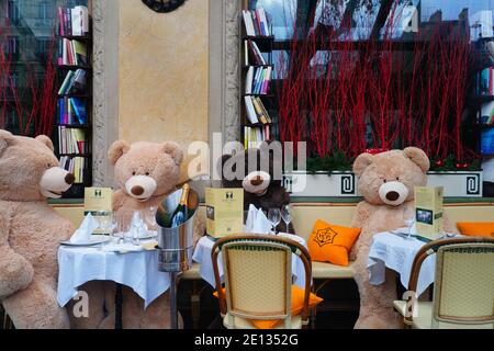 PARIS, FRANCE -24 DEC 2020- View of giant teddy bears at tables in the empty Les Deux Magots cafe in Saint-Germain des Pres during the 2020 COVID-19 p Stock Photo