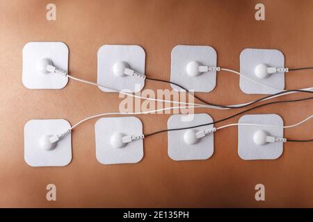 Electrode Stimulating massage of the spine at home. Medical procedure for muscle tone and beauty Stock Photo