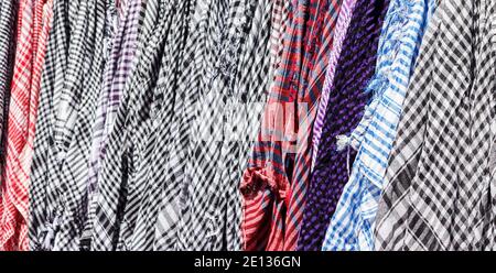 Traditional Keffiyeh or kefia hanging on hangers on bazaar in Egypt. Stock Photo