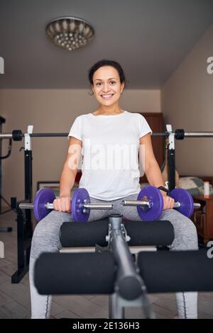 Smiling bodybuilder with a pair of dumbbells Stock Photo