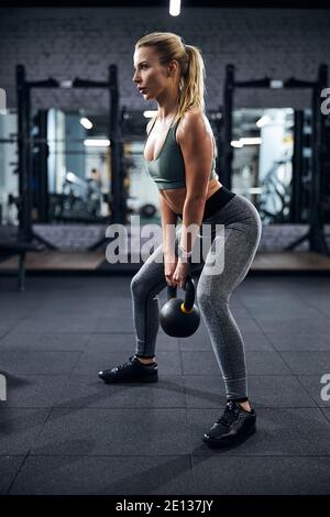 Person with kettlebell doing a sumo squat Stock Photo