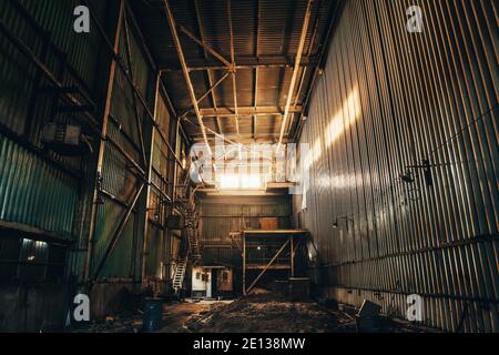 Industrial warehouse or factory building inside, abandoned or empty manufacturing, toned Stock Photo
