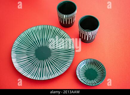 a grey ceramic plate set on a red background landscape Stock Photo
