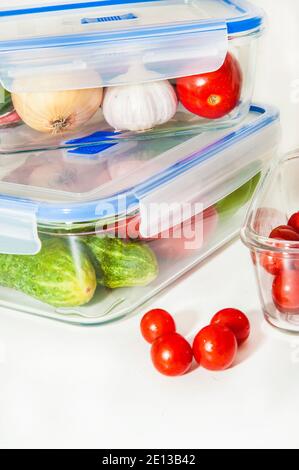 Glass food containers with fresh different vegetables on white background Stock Photo