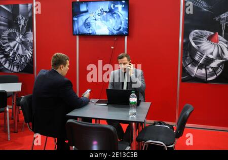 Engaging in dialogue. Manager talking to businessman sitting at the table. 18-th Industrial Exhibition. November 19, 2019. Kiev, Ukraine Stock Photo