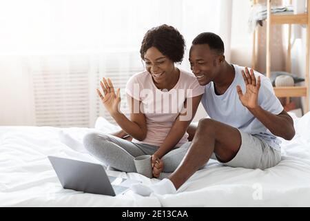 Cheerful black couple having online party, using laptop Stock Photo