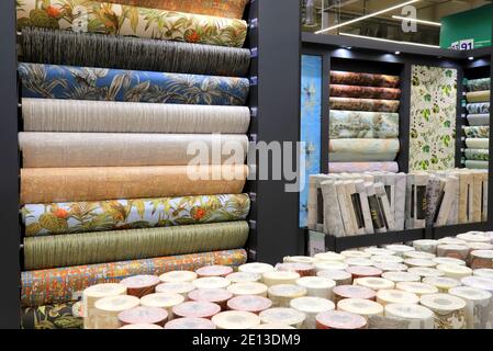 Rolls of vinyl quality wallpaper in a building supermarket, store, market. Dense wallpapers of different colors and patterns for walls, finishing Stock Photo