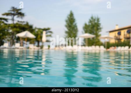 Beautiful house, swimming pool view from the veranda, summer day (Focus on pool water) Stock Photo