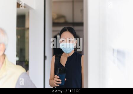 Woman wearing a medical face mask under quarantine at home. Stock Photo