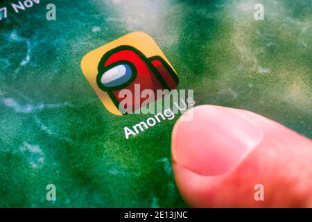 Tambov, Russian Federation - November 17, 2020 Person finger ready to start Among Us application on iPad. Close-up. Stock Photo