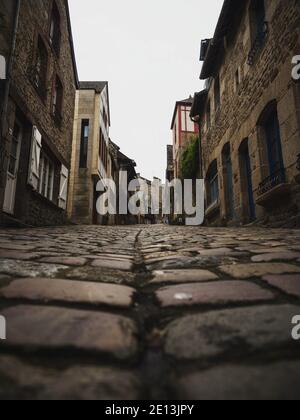 Narrow cobblestone alley lane street in historic village town of Dinan in Cotes dArmor Brittany France in Europe Stock Photo