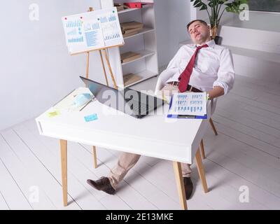 Tired worker sleeping alone at night in the office at work. Stock Photo