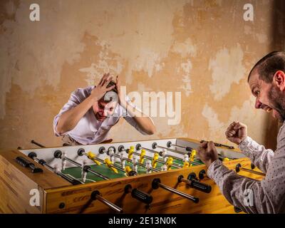 Table football victory. Two men are having fun in the evening. Stock Photo