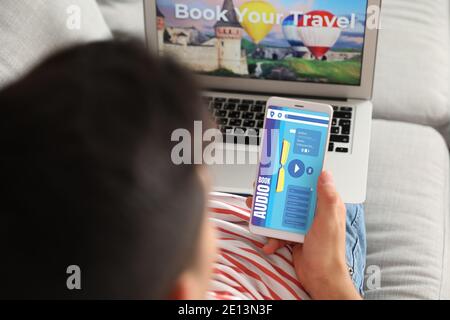 Man using audiobook application on modern smartphone at home Stock Photo