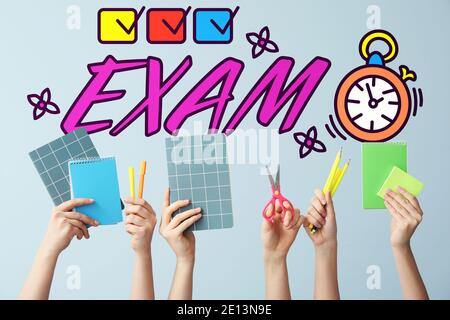 Text "Exam" and many hands with school supplies on color background Stock Photo