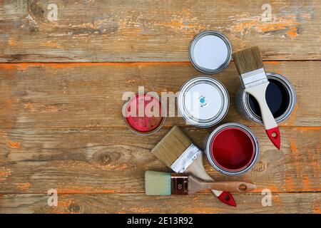 Paint cans and brushes on the old wooden background. Concept of house renovation Stock Photo