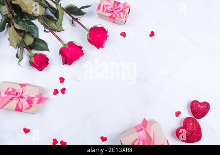 Rose flowers with presents on table from above with copy space, flat lay. Stock Photo