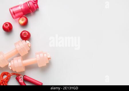Sports equipment with apples on light background Stock Photo