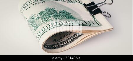 Roll of a hundred American dollars close-up on a gray background. Close-up, free space for captions and text. Stock Photo