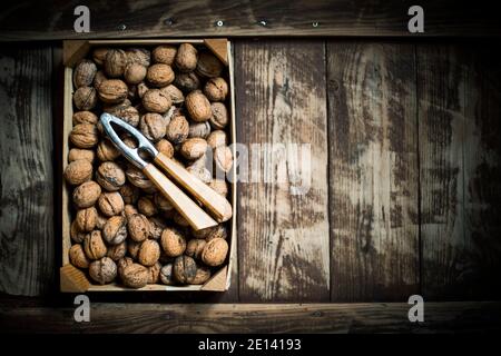 Walnuts In A Box With A Nutcracker On A Brown Wooden Table Stock Photo