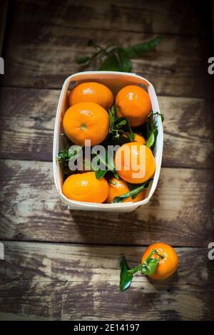 Several Mandarin Oranges On A Wooden Table Stock Photo
