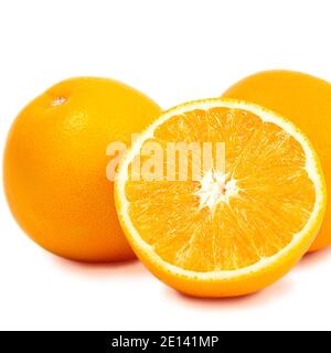 Two whole oranges and half an orange isolated on a white background, close-up macro. Stock Photo