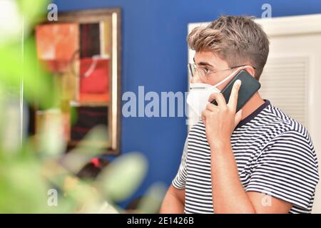 Close up of a young man using a face mask and talking on his phone Stock Photo