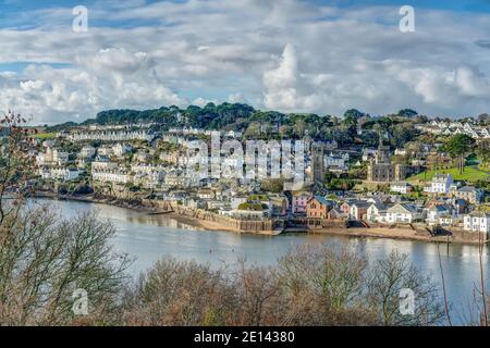 A near still winters day looking across from the Hall Walk towards the Cornish harbour town of Fowey in Cornwall. A feint reflection in the estuary. Stock Photo