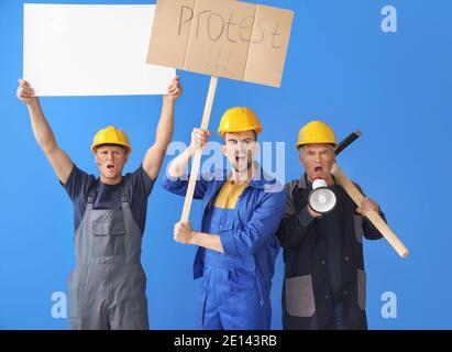Protesting miner men with placards on color background Stock Photo