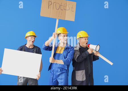 Protesting miner men with placards on color background Stock Photo